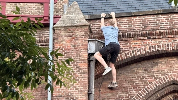 Foto: Politie houdt man aan die dak van Oude Kerk in Delft beklom