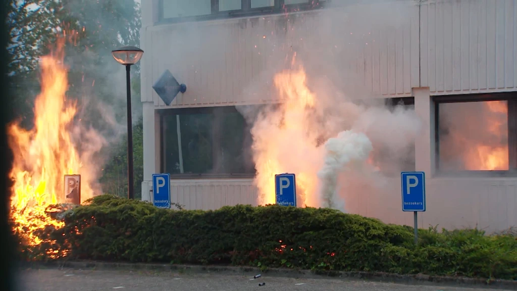Foto: Brand bij noodopvang Loosdrecht door vuurwerk, betogers houden brandweer tegen