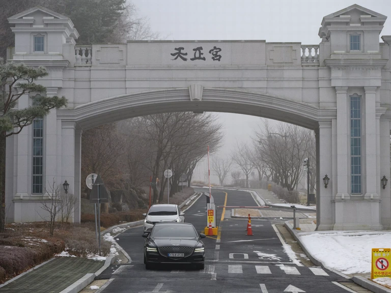Voertuigen verlaten de ingang van de Verenigingskerken residentie van de leider Hak Ja Han in Gapyeong, Zuid-Korea