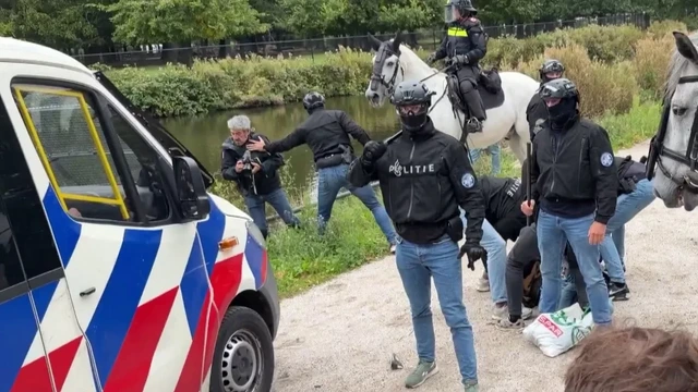 Agent duwt fotograaf in het water