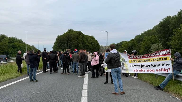 Foto: Betogers tegen komst azc lopen met fakkels snelweg bij Den Bosch op