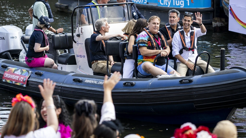 Drukte bij Amsterdamse grachten voor Canal Parade, feest in volle gang