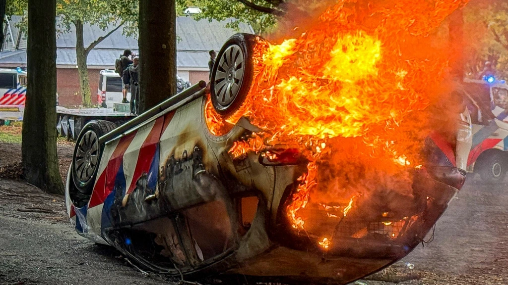 Foto: Twee jaar cel geëist tegen man die politieauto in brand stak bij rellen Malieveld 